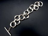 a close up of a silver bracelet on a black surface