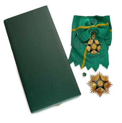 un livre vert orné d'une étoile dorée et d'un ruban vert sur lequel figure une étoile