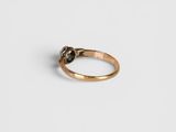 a close up of a gold ring with a black diamond