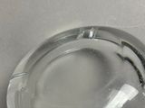 a glass ashtray on a table with a white table cloth