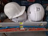 two hard hats sitting on top of a work bench