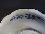 a white bowl with blue flowers on it on a table
