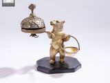 une statue représentant un ours tenant une cloche et un panier