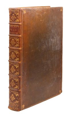 un livre ancien avec une couverture en cuir marron et des bordures dorées