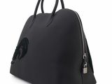 a black leather handbag with a dragon on the front