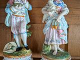 deux figurines représentant un garçon et une fille, posées sur une étagère