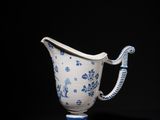a blue and white vase with a handle on a black background