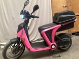 une trottinette rose garée dans un garage