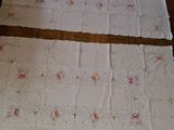 two pieces of white cloth on the floor with pink flowers on them
