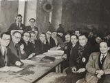 a group of men sitting at a long table together