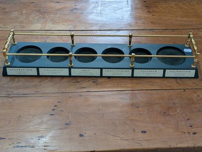a wooden table topped with a metal and glass holder