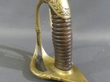 une épée dorée et marron posée sur un socle