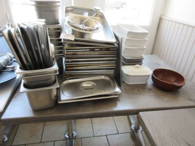 de nombreuses casseroles et poêles posées sur une table dans une cuisine