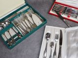 une boîte contenant des couverts, posée sur une table à côté d'un couteau, d'une fourchette et d'une cuillère