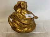 gold plated figurine of a woman holding a bowl
