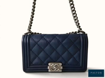 Le sac Chanel est bleu et possède une bandoulière en chaîne.