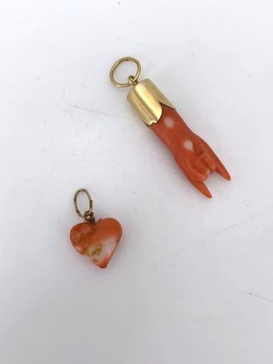 deux bijoux en corail et en or sur une surface blanche