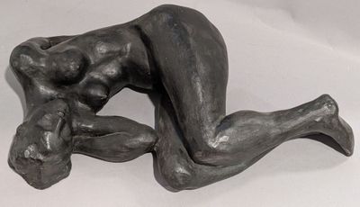 sculpture représentant une femme allongée sur le dos sur une surface blanche
