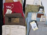 many different types of men ' s pants on the bed