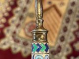 a silver candle holder with a colorful design on it