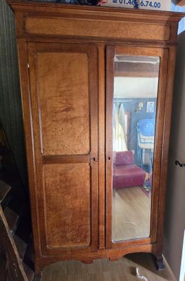 a wooden armoire with a mirror on top of it