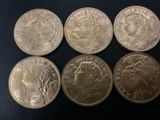 six different british coins on a black surface