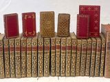 several books are stacked on top of each other on a white surface