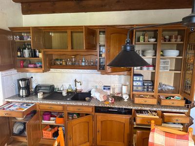 une cuisine avec des placards en bois et une plaque de cuisson noire