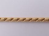 a close up of a gold chain on a white surface