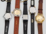 several watches are lined up on a white surface