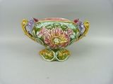a small vase with flowers on it on a white surface