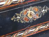 a close up of a black and gold chest of drawers