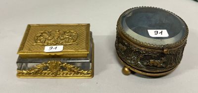 une petite boîte en or et une autre petite boîte en or posées sur une table