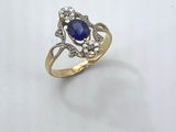 a close up of a gold ring with a blue stone and diamonds