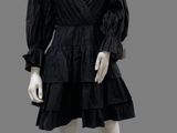a mannequin wearing a black dress with ruffles on it