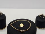 un gros plan sur un collier, un bracelet et une bague posés sur une table