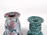 two vases sitting next to each other on a white surface
