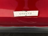 the back end of a red car with a sticker on it ' s bumper