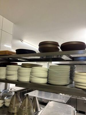many plates and pans on the shelves in the kitchen