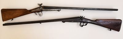 trois vieilles armes à feu sont exposées sur une surface blanche