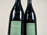two bottles of wine sitting next to each other on a table