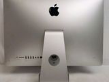 a silver apple computer sitting on top of a white table