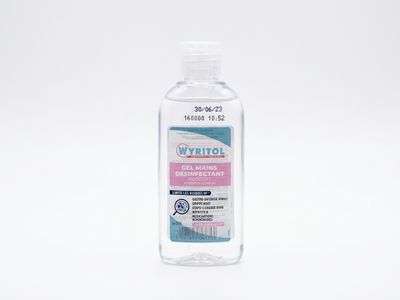 un flacon de gel hydroalcoolique posé sur une surface blanche