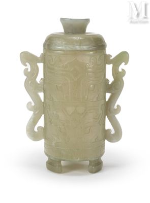 un vase vert orné de sculptures sur un fond blanc