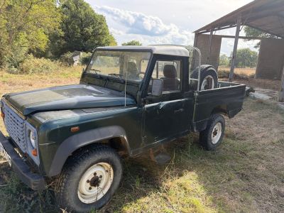 a green truck that is parked in the grass