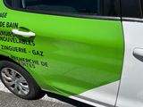 a green and white car parked on the side of the road