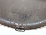 a metal pan with a handle on a white table