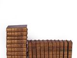 several old books stacked on top of each other on a white surface