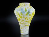 vase en verre jaune et blanc sur fond noir, avec reflet