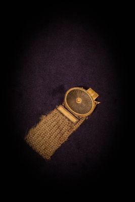 a close up of a watch on a purple surface with a black background